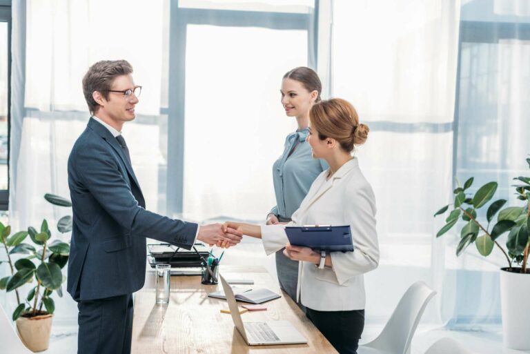 happy employee shaking hands with recruiter on job interview